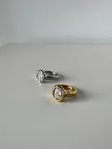 Anillo de acero quirúrgico con diseño de banda irregular y piedra central engastada.