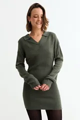 Vestido corto de tejido de punto color verde oliva, con cuello polo, escote en V y mangas largas. Presenta un diseño ajustado con textura acanalada.