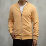 Campera bomber color durazno de algodón, con cierre frontal y cuello redondo.