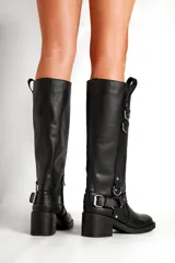 Botas de cuero negras de caña alta con hebillas y apliques metálicos.