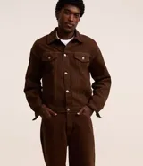 Pantalón super baggy de sarga color marrón, con trabillas en la cintura, bolsillos y cierre delantero con botón y cremallera.