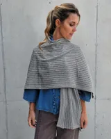 Ruana gris de tejido punto texturizado, con diseño amplio y envolvente que se puede usar como bufanda o capa.