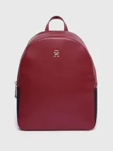 Mochila Tommy Hilfiger color rojo con detalles en azul marino. Tiene asa superior, dos correas ajustables, logo monograma metalizado de TH y cierre con cremallera.