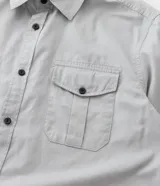 Camisa de manga larga Marfinno en tejido de sarga color gris, con cuello camisero, cierre frontal de botones y dos bolsillos frontales con solapa y botón.