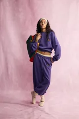 Pantalón jogger morado con efecto lavado de tiro medio y cintura elástica. Presenta bolsillos laterales ocultos, bajo con puño elástico y detalle de logo bordado de Fruit of the Loom en la cadera.