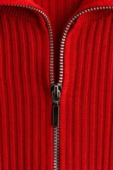 Top de manga larga confeccionado en tejido de punto acanalado. Presenta un diseño de ajuste ceñido con cuello alto y cierre frontal parcial.