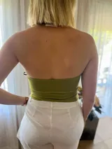 Top verde oliva con escote halter y abertura en el abdomen, con hebilla metálica plateada.