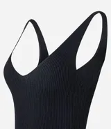 Blusa sin mangas de punto acanalado color crema, con escote en V y espalda descubierta. Confeccionada en una mezcla de viscosa y poliamida, presenta un ajuste al cuerpo y textura vertical en relieve.