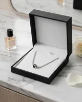 Gargantilla de plata 925 con cadena de eslabones pequeños engastados con circonias blancas y un dije central en forma de tambor con circonias negras.