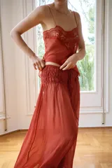 Musculosa de georgette en color bordó, con escote recto, tirantes finos y detalle de aplicación de encaje floral en la parte superior.
