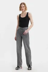 Jean de corte baggy y tiro medio, con diseño de costuras retorcidas y abertura en el ruedo. Presenta cierre de botones a la vista y un acabado lavado en tono gris.