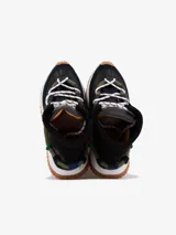 Bota de caña media color negro, con cordones y suela track color caramelo.