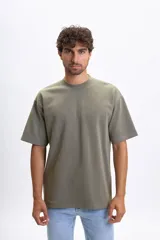 Camiseta de manga corta color verde, con cuello redondo y corte holgado.