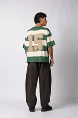 Remera tejida de manga corta con diseño de rayas horizontales anchas en color bordó y crema, de corte relajado y cuello redondo.