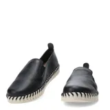 Zapatos tipo slip-on de cuero negro con diseño de textura granulada. Presentan una suela de goma blanca con detalle de costuras decorativas en contraste a lo largo de todo el borde.
