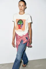 Camiseta blanca de manga corta y cuello redondo, de corte regular con estampa frontal artística y colorida de un rostro estilo abstracto.