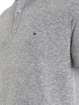 Chomba gris de Tommy Hilfiger, corte regular, con cuello tipo chomba, cartera de dos botones, diseño de rayas en el interior del cuello y logo bordado en el pecho.