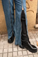 Pantalón de jean azul con cierre metálico en la parte inferior de la pierna.