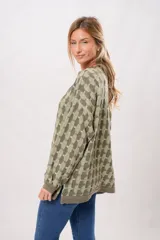 Buzo oversize de punto color verde oliva con cuello alto y diseño geométrico en dos tonos.