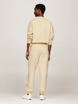 Pantalón de jogging color crema, de corte cónico, con cintura elástica ajustable con cordón, bolsillos laterales y logo bordado en la pierna.