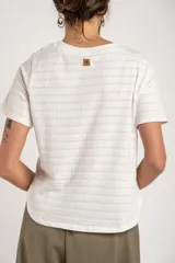Remera blanca de manga corta con cuello redondo y textura de líneas horizontales con perforaciones.