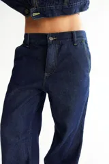 Pantalón de jean azul oscuro, de corte baggy y tiro bajo, con pespuntes a contratono color verde lima y logo bordado en el bolsillo trasero. Confeccionado en denim 100% algodón.