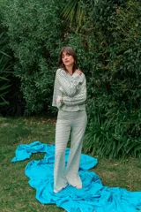 Conjunto de dos piezas de rib blanco con rayas horizontales negras, compuesto por un buzo oversize de mangas largas acampanadas y un pantalón de corte recto y holgado.
