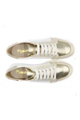 Zapatillas deportivas de cuero, combinando paneles en color blanco y detalles metalizados en tono dorado. Presentan cierre mediante cordones blancos y suela de goma plana.