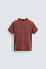 Remera de punto de algodón con efecto lavado, corte relajado, cuello redondo y mangas ranglán cortas. Presenta estampados a contraste en la parte delantera.