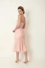 Vestido midi de cruni color rosa pastel, con escote corazón, breteles finos y falda con volados.