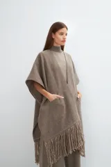 Ruana marrón con flecos y bolsillos. Terminaciones envivadas.
