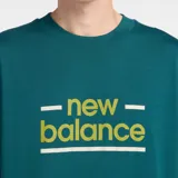 Remera de algodón color verde petróleo, con cuello redondo y mangas cortas. Presenta un estampado frontal con el logo de New Balance en color amarillo y líneas horizontales decorativas.