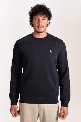 Buzo de cuello redondo en color azul marino, con ajuste elástico en puños y cintura. Presenta un pequeño logo bordado de un pingüino en el lado izquierdo del pecho.