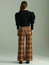 Cardigan marrón de tejido de punto con cierre frontal, cuello redondo y mangas abullonadas con apliques de pompones.