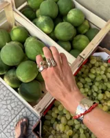 Anillo de diseño orgánico y macizo con forma irregular, elaborado en metal con acabado brillante. Presenta una estructura abierta que permite su ajuste.