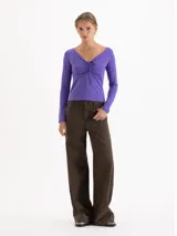 Top de manga larga color violeta, con escote en V y detalle de fruncido central regulable mediante lazos finos en el delantero. Presenta un ajuste entallado al cuerpo.