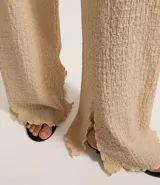 Pantalón texturizado marrón de corte ancho con cintura elástica y bolsillos laterales.