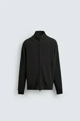 Chaqueta de punto tejido en algodón, con cuello subido, manga larga y cierre frontal con cremallera. Presenta un diseño de punto perlado con acabados en rib en puños y ruedo.