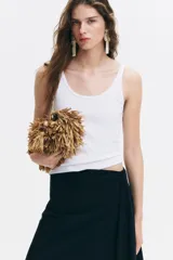 Musculosa blanca de punto acanalado, con escote en U pronunciado tanto en el frente como en la espalda y tirantes finos.