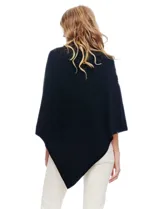 Poncho tejido color crema, con cuello polera y diseño trenzado diagonal en el frente. Presenta un corte asimétrico en el ruedo.