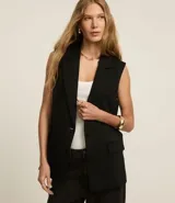 Chaleco negro de punto roma con escote blazer, cierre con dos botones y bolsillos delanteros.