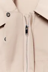 Vestido corto de cuello solapa y manga larga, con bolsillos delanteros y detalle de cinturón a tono. Presenta cierre frontal con cremallera oculta y bajo con aberturas laterales.