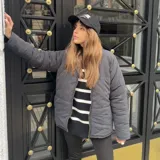 Campera puffer gris con cierre frontal y cuello alto.