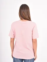 Remera de algodón color rosado con estampa frontal en color rojo con la frase Warm Hugs en tipografía retro.