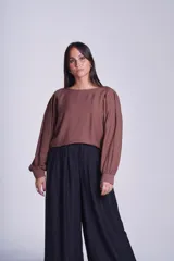 Blusa color marrón con mangas globo y tablas que aportan volumen y elegancia.