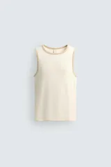 Camiseta sin mangas slim fit color crema, confeccionada en tejido de algodón elástico, con cuello redondo y ribetes en contraste color beige.