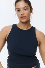 Musculosa de algodón en punto acanalado, color negro, con cuello redondo y diseño ajustado sin mangas.