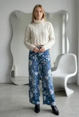 Jean de corte recto y tiro alto con estampado floral en tonos claros sobre base azul denim. Cuenta con cierre frontal y bolsillos laterales.