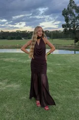 Falda larga marrón de microtul con base plisada y forrería en la parte de las caderas.