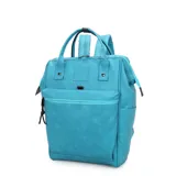 Mochila de estilo urbano color turquesa, con cierre principal tipo boca de pez y múltiples cierres exteriores. Presenta asas superiores y correas ajustables para llevar como mochila.